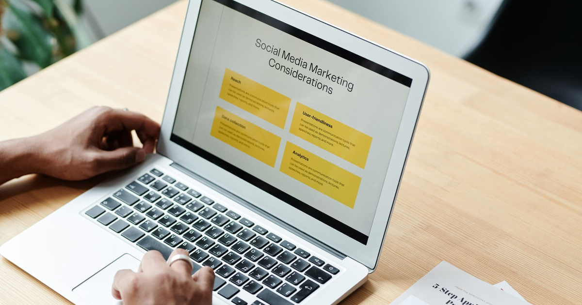 A person using a laptop to review social media marketing strategies at home.