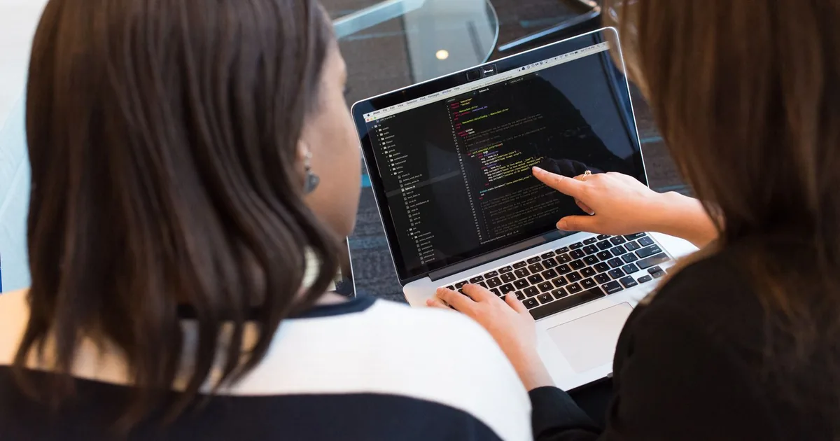 Developer reviewing website performance metrics on a dual-monitor setup.